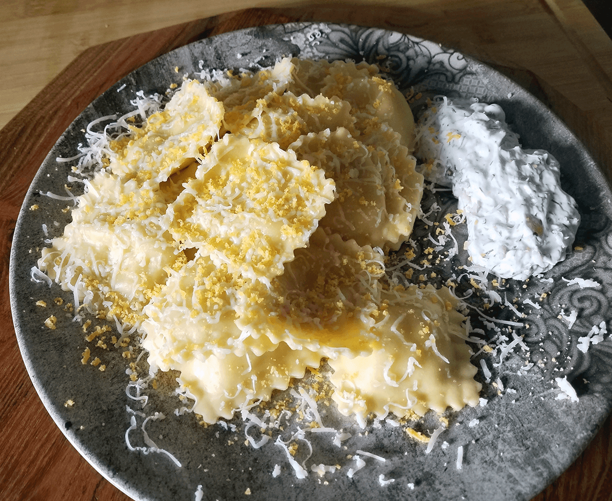 Photographie de raviolis frais avec du jaune d'œufs maturé râpé dessus